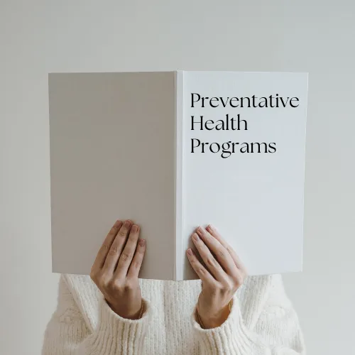 Person holding a book titled "Preventative Health Programs," emphasizing health and wellness strategies.