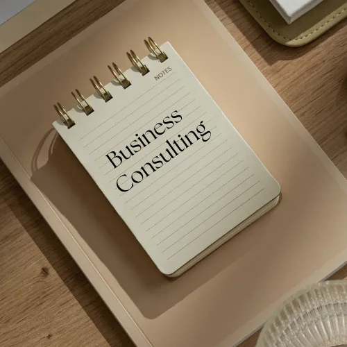 Notebook with "Business Consulting" written on the cover, placed on a wooden surface, symbolizing Sanguine Strategic Advisors' focus on providing tailored business advisory services.