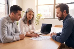 A small business team reviewing a short stack of documents together, one person pointing to a specific item