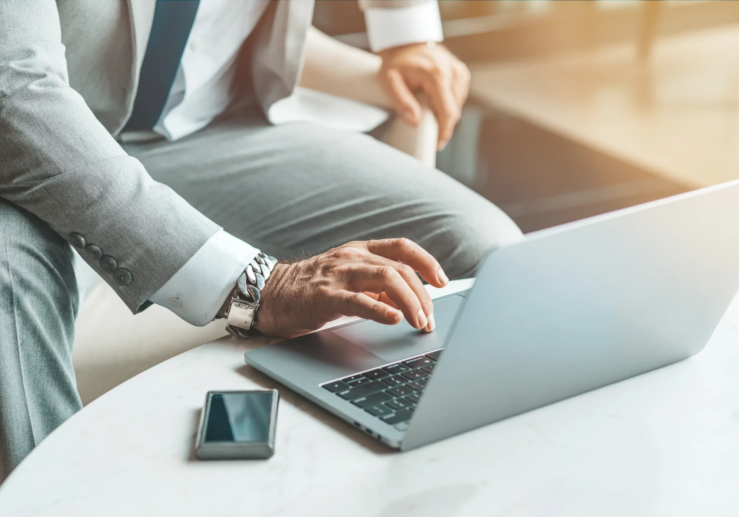Close up of focused middle-aged businessman in suit working with a laptop. E-learning and online professional education concept. Horizontal shot