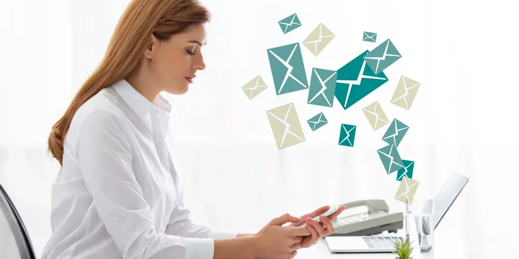Side view of businesswoman using smartphone near documents and laptop on table, e mail illustration Side view of businesswoman using smartphone near documents and laptop on table, e mail illustration